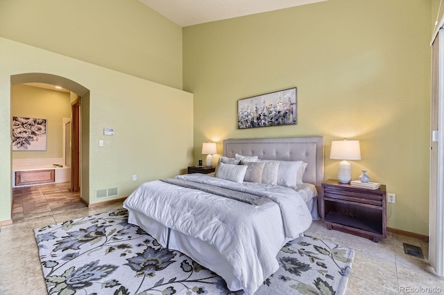 bedroom with arched walkways, a high ceiling, visible vents, and baseboards