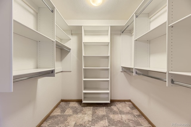 walk in closet with stone finish flooring