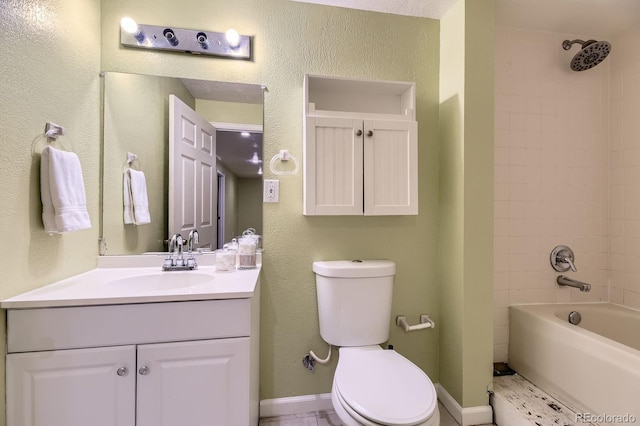 bathroom with a textured wall, toilet, vanity, baseboards, and  shower combination