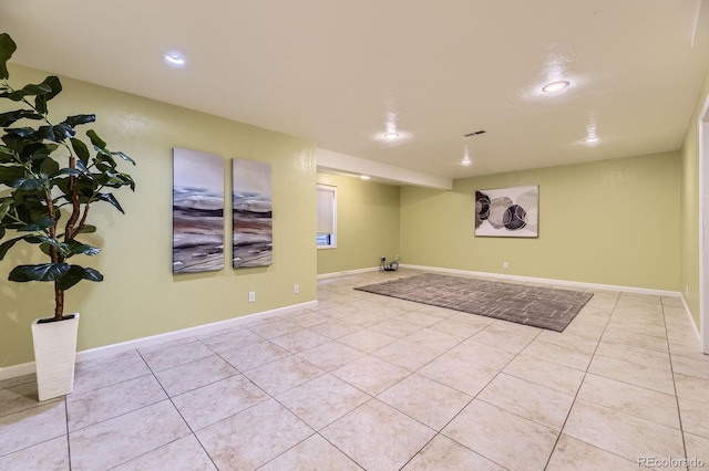 finished below grade area featuring recessed lighting, visible vents, baseboards, and light tile patterned floors