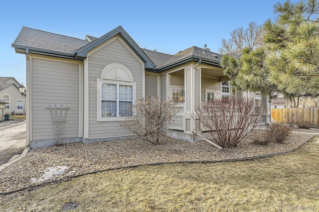 exterior space with fence and a shingled roof