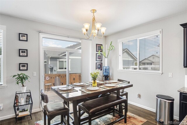 dining space featuring dark wood-type flooring and an inviting chandelier