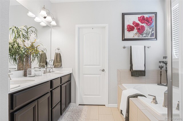 bathroom with a tub to relax in, vanity, and tile patterned flooring