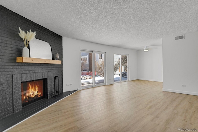 unfurnished living room with a textured ceiling, a fireplace, and wood-type flooring