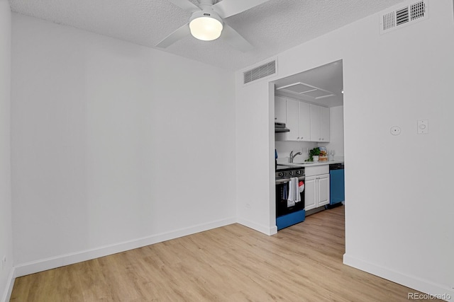 spare room with ceiling fan, sink, a textured ceiling, and light wood-type flooring