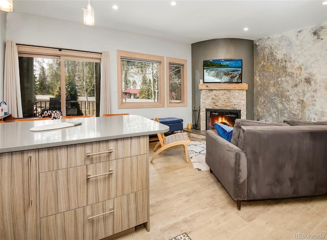 living area with a fireplace, recessed lighting, and light wood-style flooring