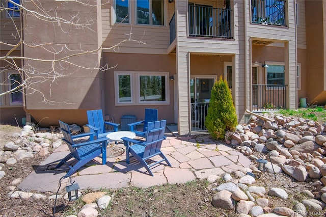 rear view of property featuring a patio and a balcony