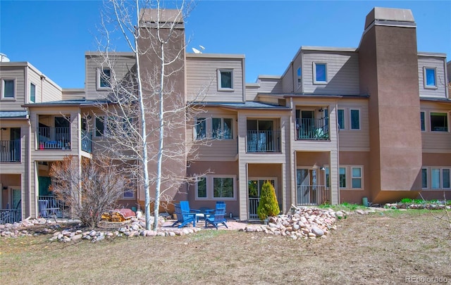rear view of house featuring a patio area and a chimney