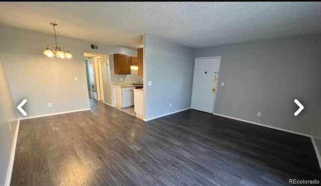 unfurnished living room with dark wood-style floors, a textured ceiling, visible vents, and baseboards