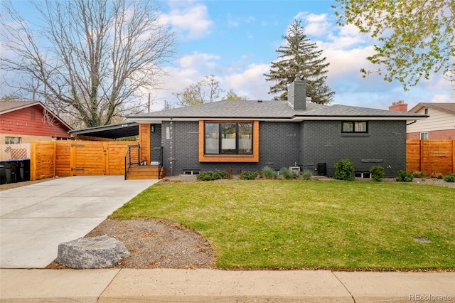 view of front of house with fence, driveway, a front lawn, and brick siding