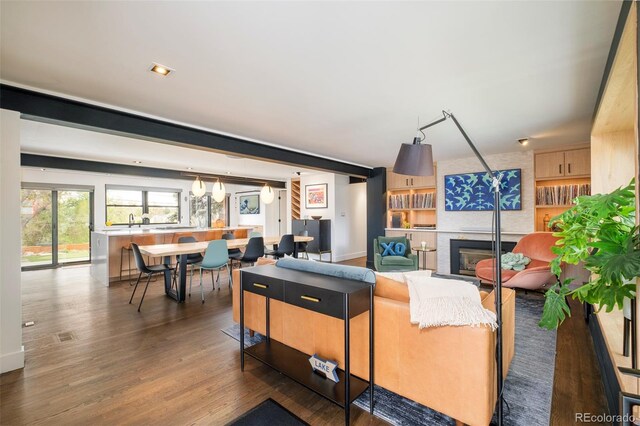living room featuring a large fireplace and wood finished floors