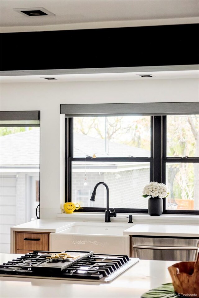 kitchen with light countertops, stainless steel appliances, a sink, and visible vents