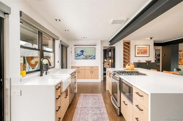 kitchen with a sink, light brown cabinets, dark wood-type flooring, visible vents, and modern cabinets
