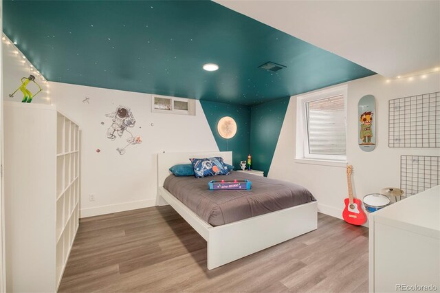 bedroom featuring baseboards, recessed lighting, wood finished floors, and visible vents