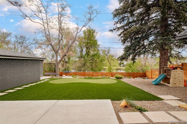 view of yard with a fenced backyard and a playground