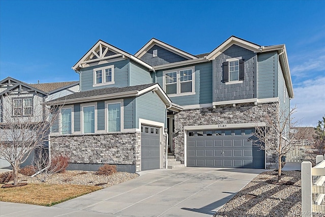 craftsman inspired home featuring stone siding, driveway, and an attached garage