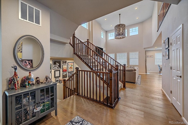 foyer entrance featuring visible vents, hardwood / wood-style floors, and stairway