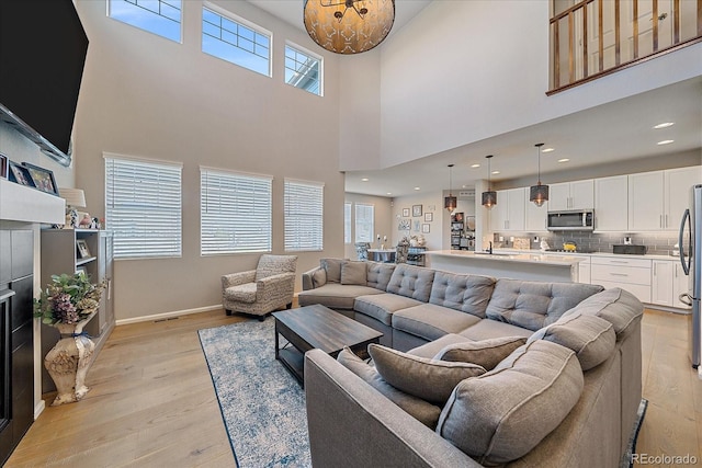 living area featuring recessed lighting, baseboards, and light wood-style floors