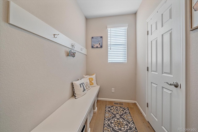 mudroom with visible vents, baseboards, and light wood-style floors