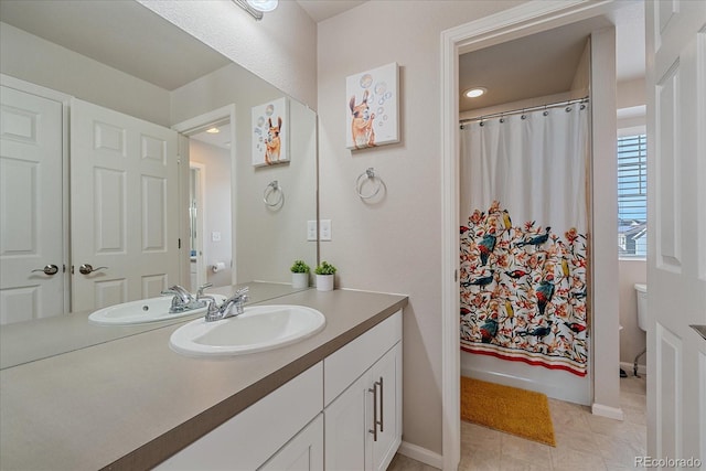 bathroom with vanity, tile patterned floors, toilet, and baseboards