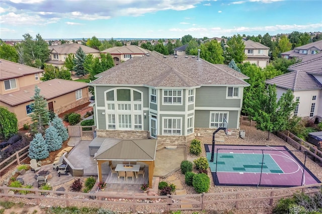 back of property with basketball court and a patio