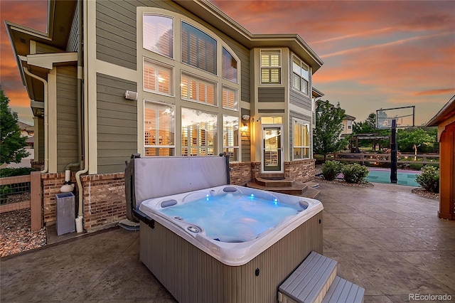 patio terrace at dusk with a hot tub