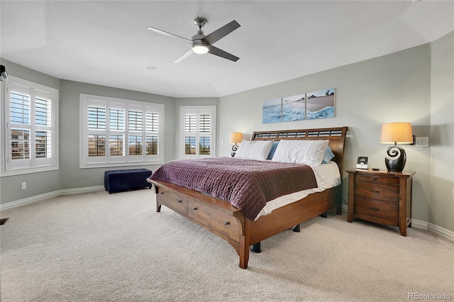 bedroom with multiple windows, light colored carpet, and ceiling fan