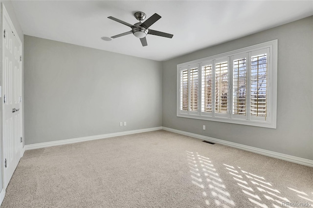 empty room featuring ceiling fan and light colored carpet