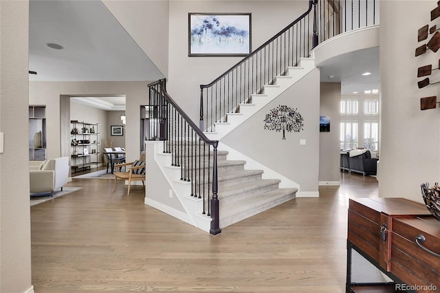 foyer entrance featuring light hardwood / wood-style flooring and a high ceiling