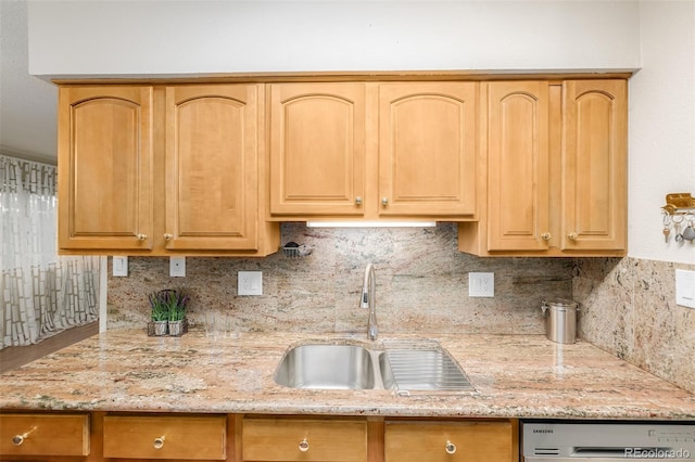 kitchen featuring stainless steel dishwasher, decorative backsplash, light stone counters, and sink