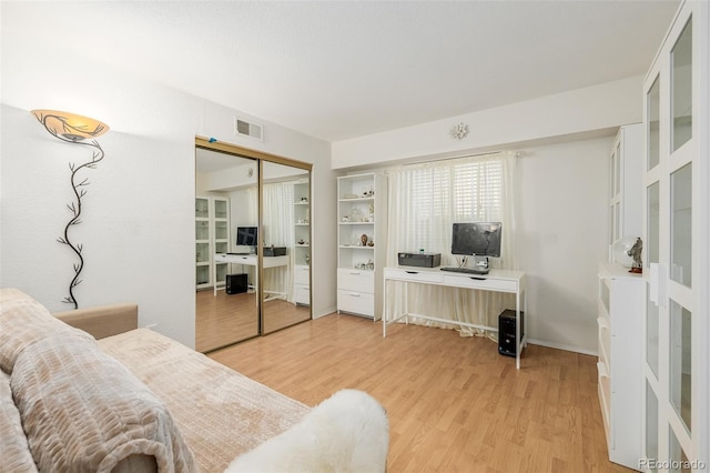 office space with built in shelves and hardwood / wood-style floors