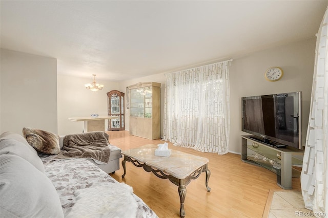 living room featuring light hardwood / wood-style floors and an inviting chandelier