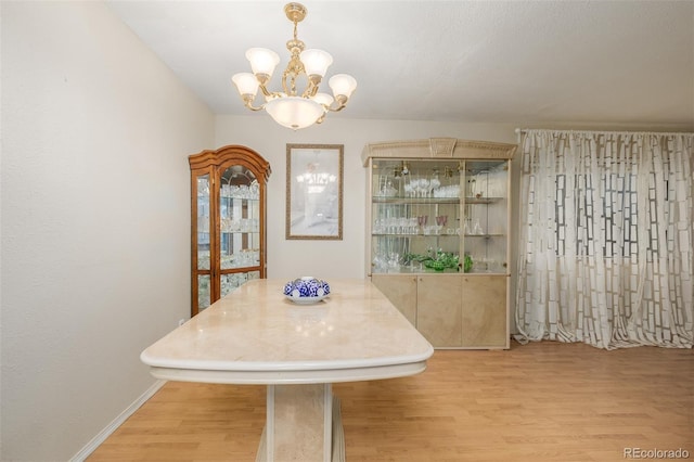 unfurnished dining area featuring a chandelier and light wood-type flooring