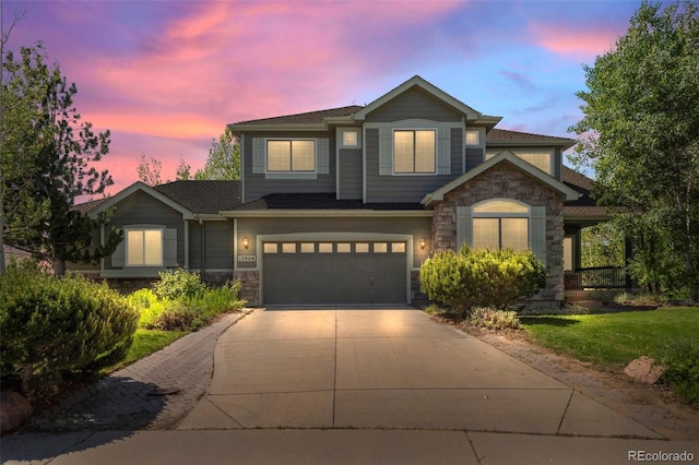 view of front of home with stone siding, driveway, and an attached garage