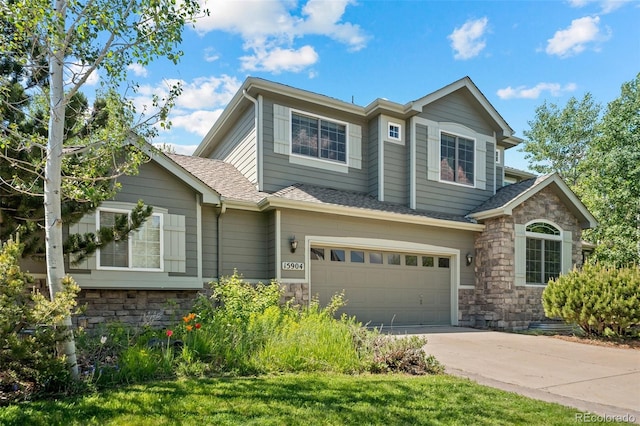 view of front of house featuring stone siding, an attached garage, concrete driveway, and roof with shingles