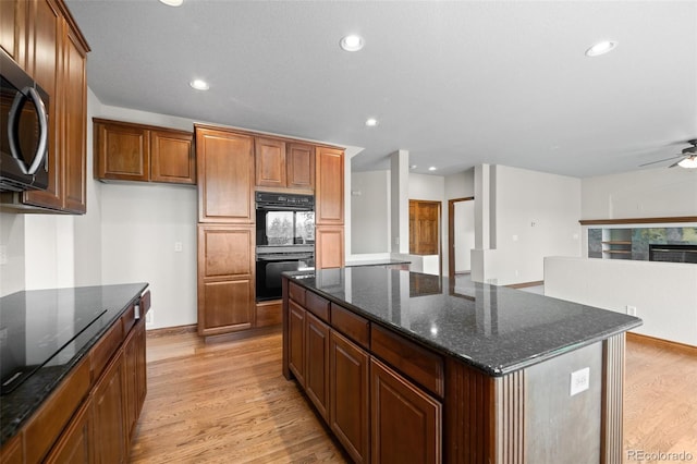 kitchen with black appliances, light wood-type flooring, a kitchen island, ceiling fan, and recessed lighting
