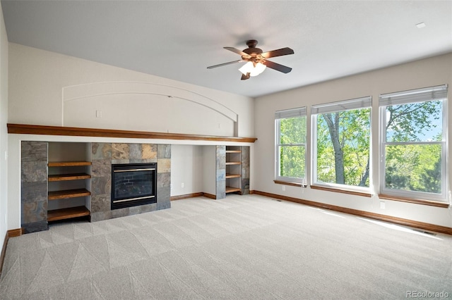 unfurnished living room with a fireplace, baseboards, carpet floors, and ceiling fan