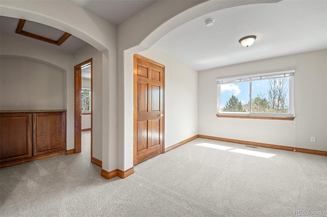 unfurnished bedroom featuring carpet flooring, multiple windows, and baseboards