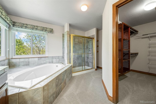 full bath with a stall shower, a bath, a walk in closet, vanity, and baseboards