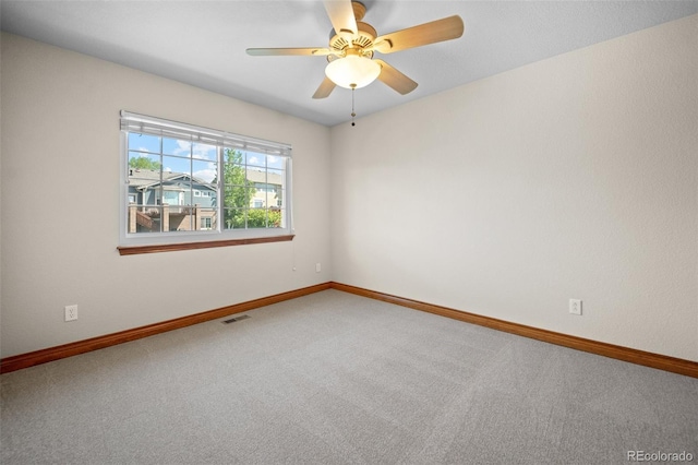 empty room featuring carpet, baseboards, and a ceiling fan