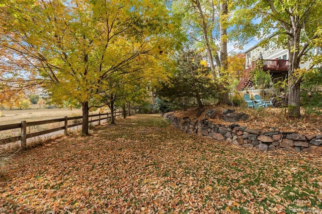 view of yard with fence, stairs, and a wooden deck