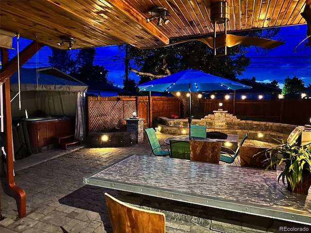 4779 S Bannock St, Englewood, CO 80110 - patio at twilight with a hot tub, outdoor dining space, a fenced backyard, and a patio