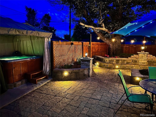 4779 S Bannock St, Englewood, CO 80110 - patio at night featuring a hot tub, a patio area, and a fenced backyard