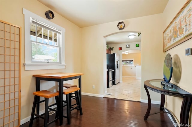 4779 S Bannock St, Englewood, CO 80110 - dining area featuring arched walkways, baseboards, and wood finished floors