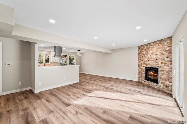 unfurnished living room featuring a fireplace and light hardwood / wood-style floors