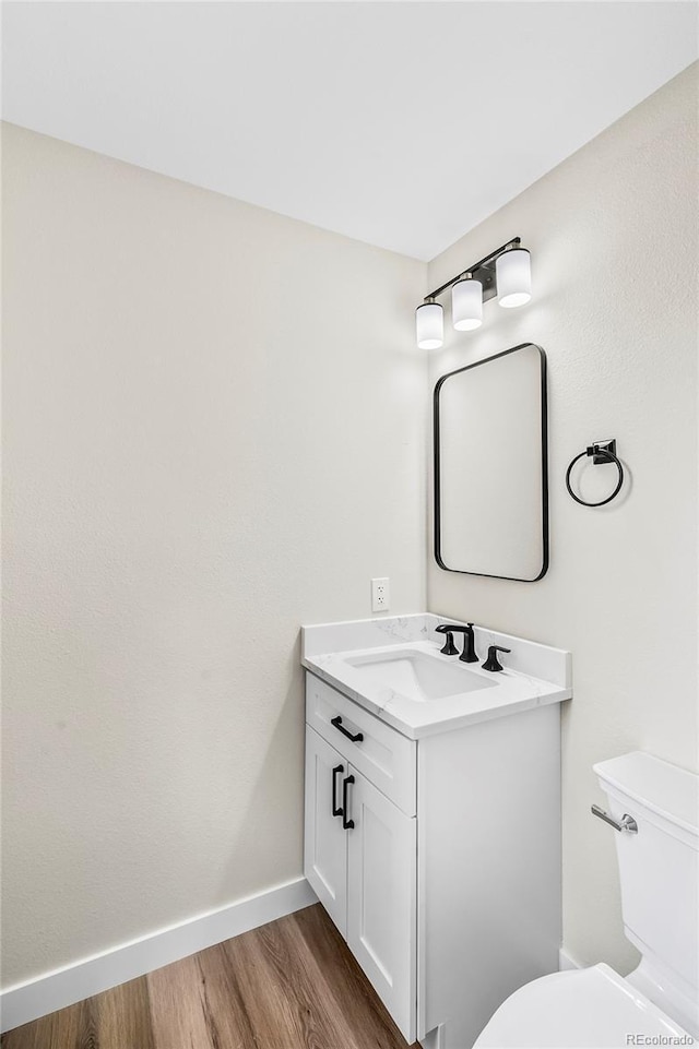 bathroom featuring hardwood / wood-style flooring, vanity, and toilet