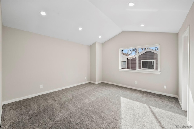 carpeted spare room featuring lofted ceiling