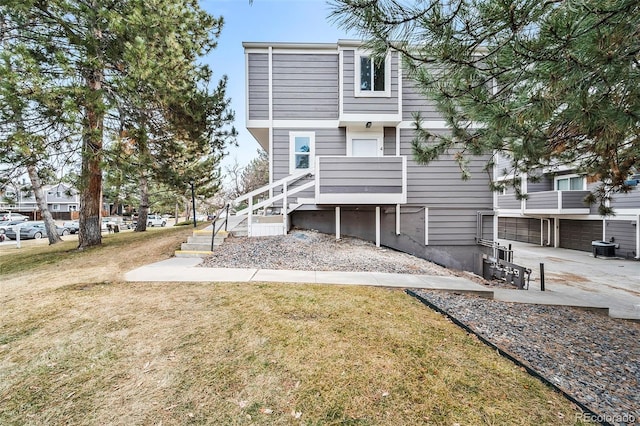 rear view of house featuring a garage and a yard