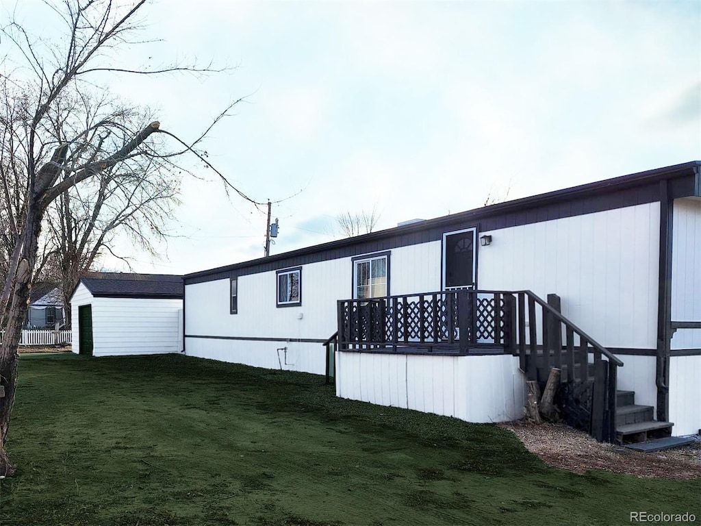 back of house with an outbuilding and a yard