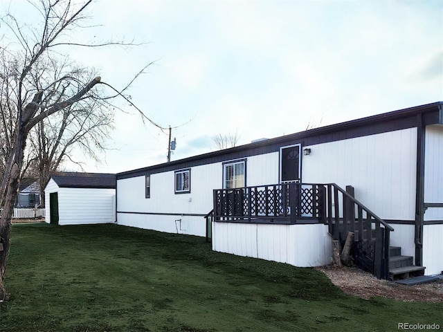 back of house with an outbuilding and a yard